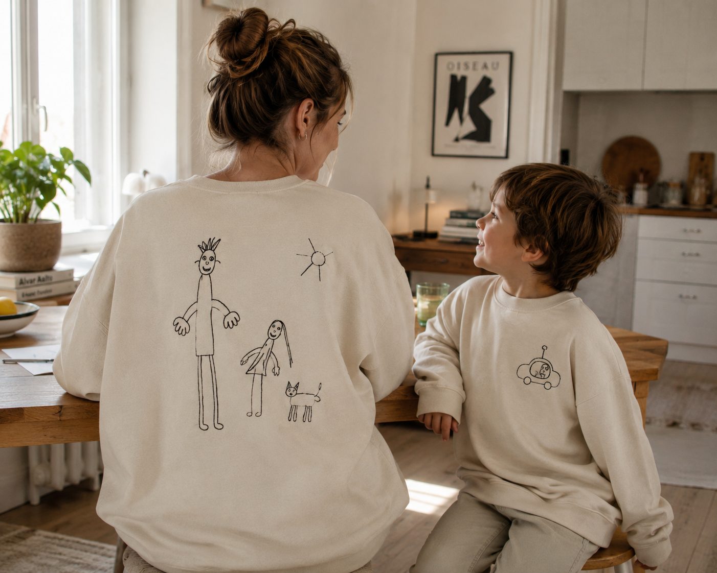 Mutter und Sohn in bestickten Sweatshirts in der Küche