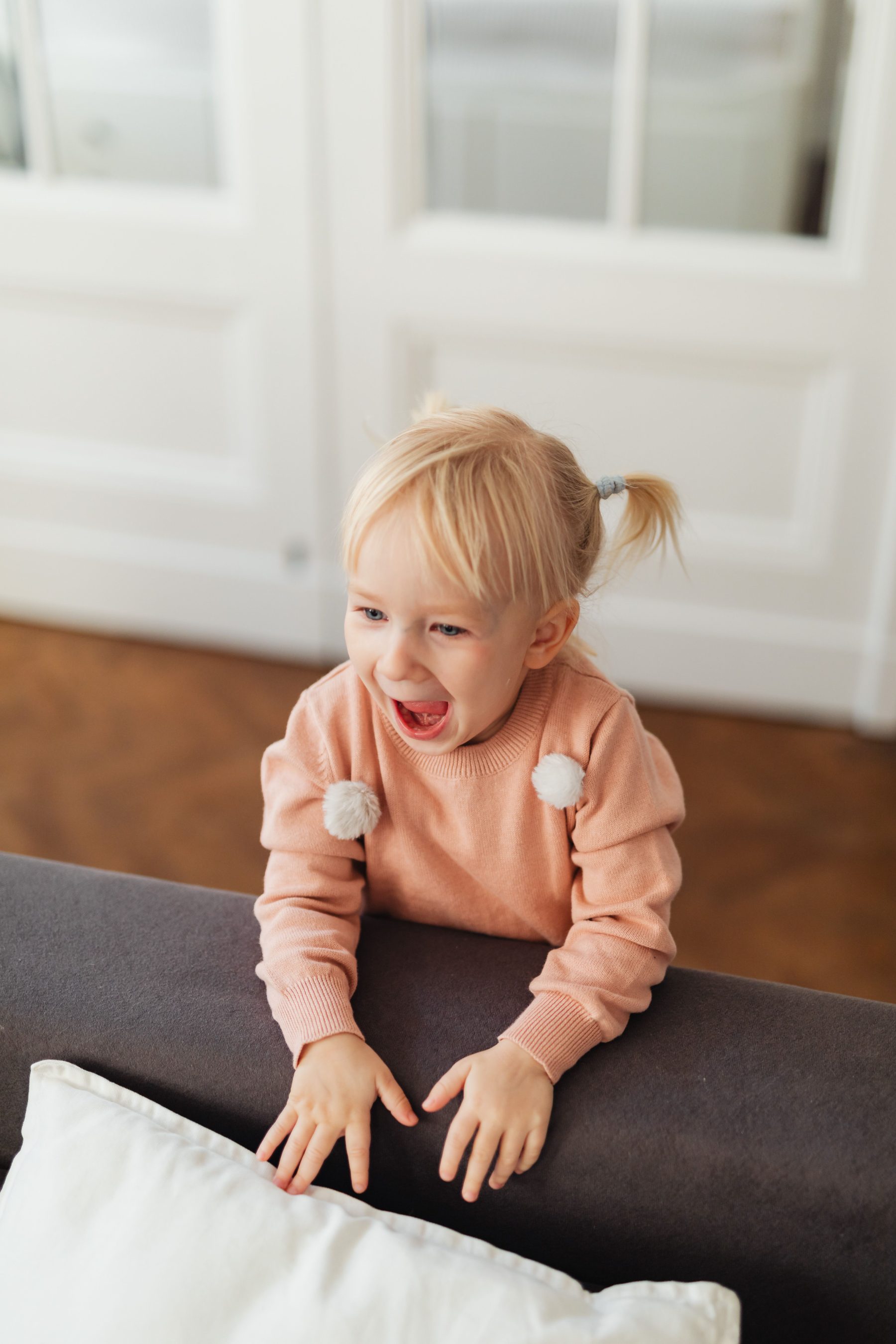 Lachendes Kleinkind im rosa Pullover